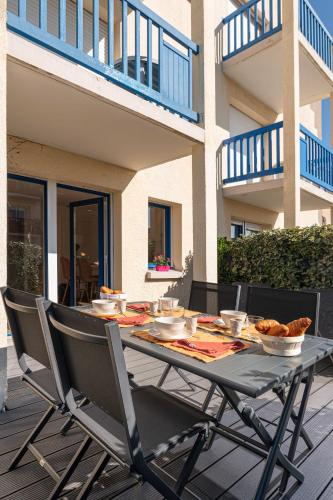 - une table avec des bols de nourriture sur la terrasse dans l'établissement Le Nid Bleu, à Ploemeur