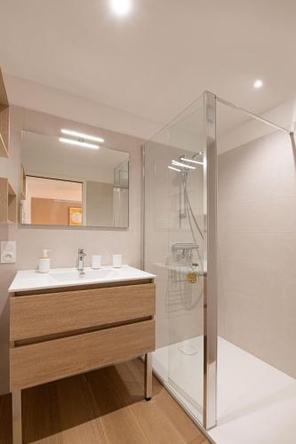 une salle de bain avec un lavabo et une douche dans l'établissement Le Nid Bleu, à Ploemeur