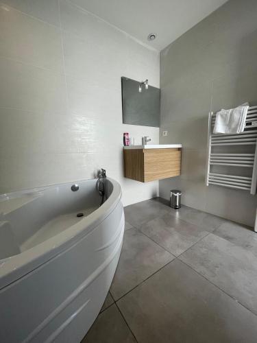 une salle de bain blanche avec une baignoire et un lavabo dans l'établissement Villa design Cap dAgde piscine et plage, au Grau-dʼAgde