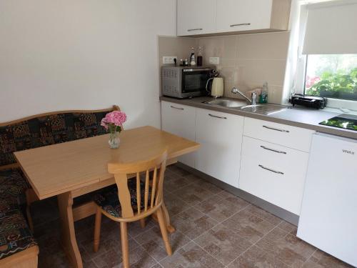 a kitchen with a wooden table and a microwave at Apartma Ob jezeru in Gradišče v Slovenskih Goricah