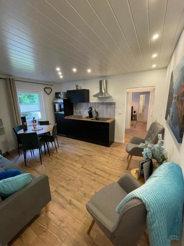 a living room with a table and chairs and a kitchen at Bergstadt Apartment Lautenthal ,Modern, Stylisch, Geräumig in Lautenthal