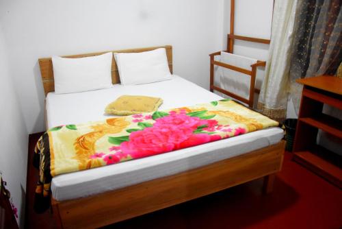 a bedroom with a bed with flowers on it at Ansi Villa in Nanu Oya