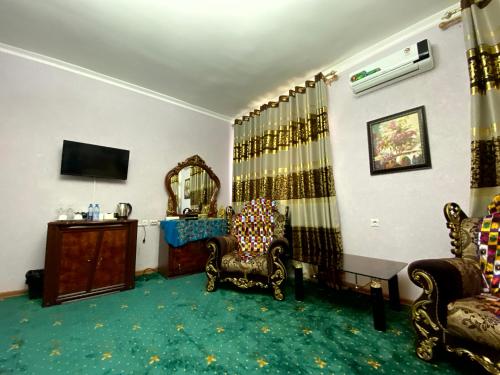 a living room with two chairs and a mirror at Qibla Tozabog in Khiva