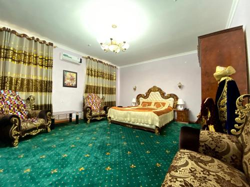 a bedroom with a bed and a couch and chairs at Qibla Tozabog in Khiva