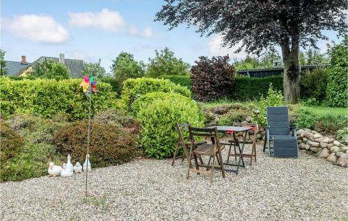 a garden with chairs and a table with a flag at 5 Bedroom Beautiful Home In Tranekær in Tranekær