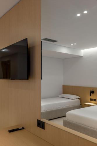a room with two beds and a flat screen tv at Austin Boutique Hotel in Sarandë
