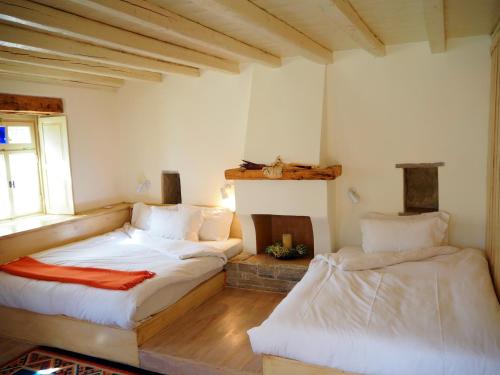 a bedroom with two beds and a window in it at Papaevangelou Hotel in Papigko