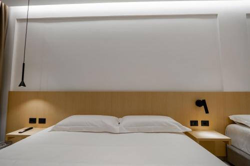 a bedroom with a large white bed with two night stands at Austin Boutique Hotel in Sarandë
