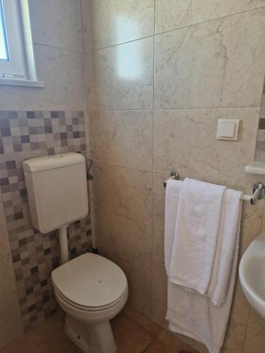 a bathroom with a toilet and a sink and towels at Bela Vista in Olhão
