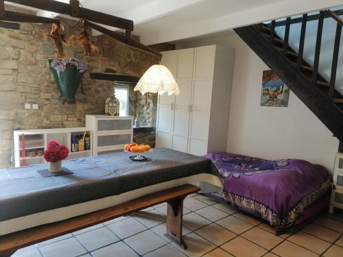a bedroom with a bed and a stone wall at Maison Paimpol in Lanleff