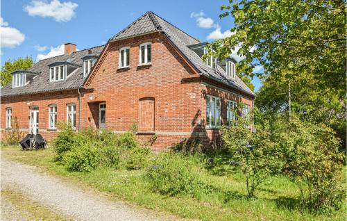 an old red brick house on a dirt road at Stunning Apartment In Skanderborg in Skanderborg