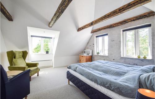 a bedroom with a bed and a green chair at Stunning Apartment In Skanderborg in Skanderborg