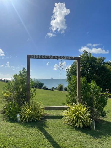a sign in the middle of a field with plants at Couleur Caraïbes-COCOBEACH MARTINIQUE PIERRE et VACANCES in Sainte-Luce