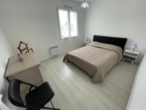 une chambre avec un lit, un bureau et une chaise dans l'établissement LA TRANCHE SUR MER centre ville emplacement voiture, à La Tranche-sur-Mer