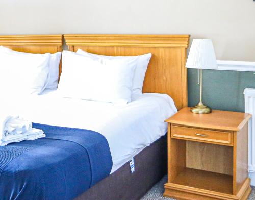 a bedroom with two beds and a table with a lamp at The Wellington Hotel in Ventnor