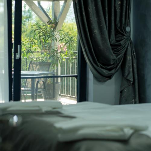 a room with a balcony with a table and a window at Casa Patry in Călimăneşti