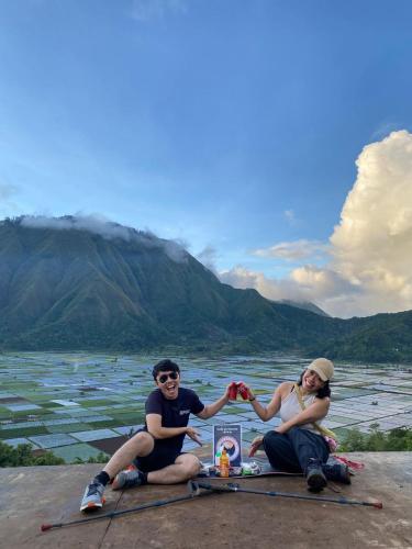 a man and woman sitting on top of a mountain at Poetri Bungalow & Restaurant in Senaru