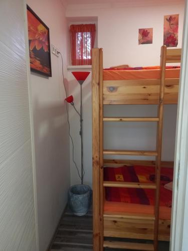 a room with two bunk beds and a lamp at Grevia Apartmanok in Poroszló