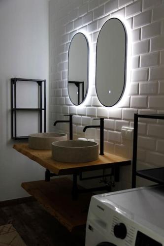 a bathroom with two sinks and two mirrors at Schättihof in Müllendorf