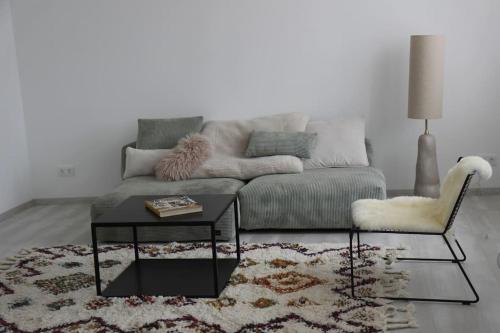 a living room with a couch and a table and a chair at Schättihof in Müllendorf