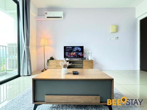 a living room with a table and a tv at Ipoh Meru Casa Kayangan by BeeStay in Ipoh