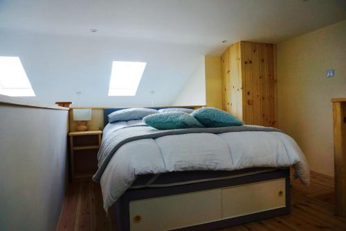 a bedroom with a bed with blue pillows on it at The Hideaway, Castle an Dinas, Cornwall TR9 6JB in Saint Columb Major