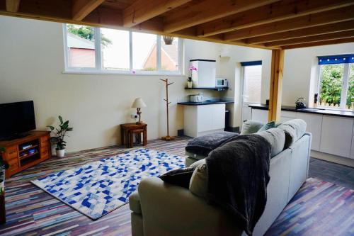 a living room with a couch and a kitchen at The Hideaway, Castle an Dinas, Cornwall TR9 6JB in Saint Columb Major