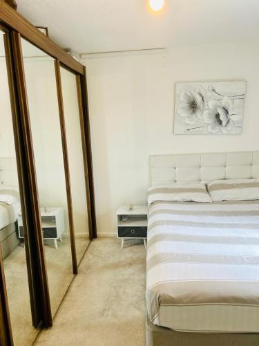 a bedroom with a white bed and a mirror at Cozy Room In Oldham, Manchester in Oldham