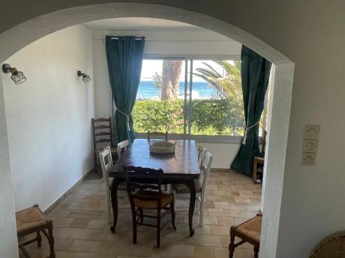 une salle à manger avec une table et une grande fenêtre dans l'établissement Au bord de mer à Hyères les Palmiers, à Hyères