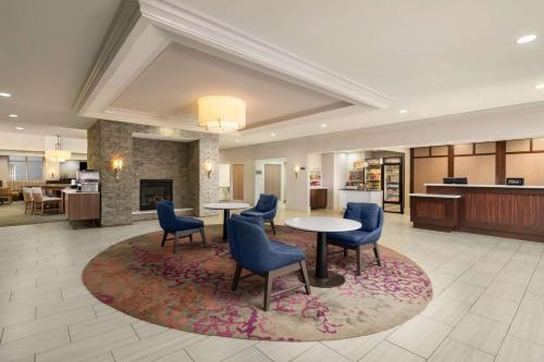 a lobby with two tables and chairs on a rug at Homewood Suites by Hilton Richmond - Airport in Sandston