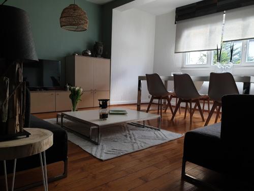 a living room with a table and chairs and a television at Happiness Cottage in Colmar