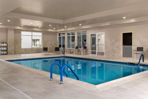 a swimming pool with blue water in a building at Homewood Suites by Hilton Richmond - Airport in Sandston
