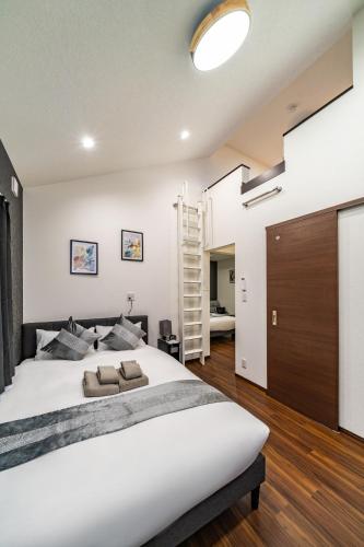 a bedroom with a large white bed and a staircase at 88, Kanegafuchi 3A, Entire house for rent, 鐘ヶ淵3A in Tokyo