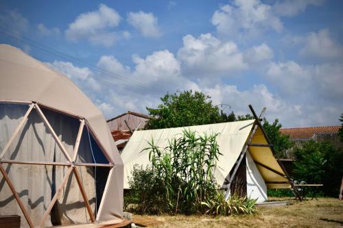 a couple of tents sitting in a yard at Parc Du Coq à l'Âne - Lodges Insolites in Saint-Georges-de-Rex