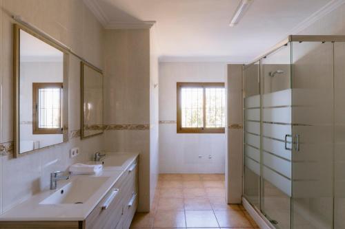 a bathroom with a sink and a glass shower at Villa Can Vincent in Sant Josep de Sa Talaia