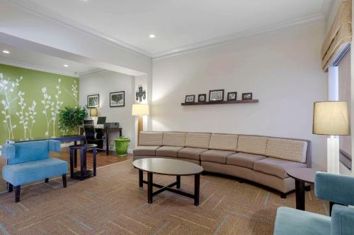 a living room with a couch and a table and chairs at Sleep Inn & Suites Cave City in Cave City