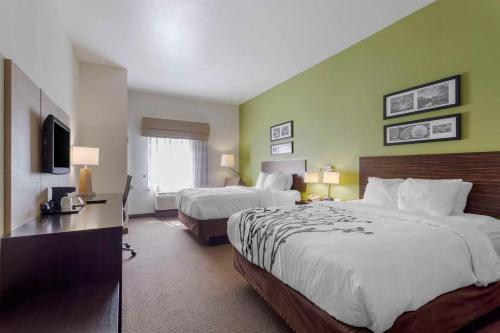 a hotel room with two beds and a television at Sleep Inn & Suites Cave City in Cave City