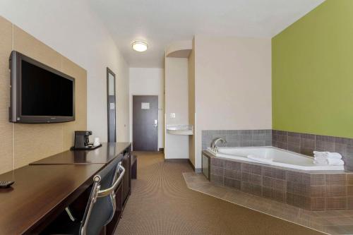 a hotel room with a tub and a tv at Sleep Inn & Suites Cave City in Cave City