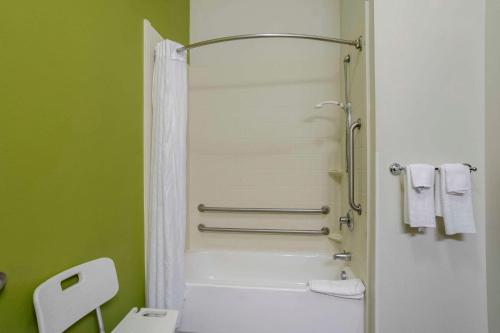a bathroom with a shower and a white tub at Sleep Inn & Suites Cave City in Cave City