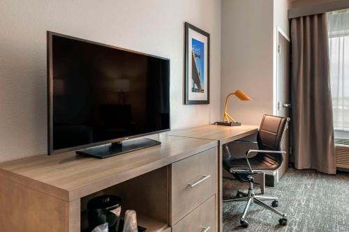 a hotel room with a television and a desk with a chair at Comfort Inn & Suites Jacksonville - Orange Park Near Naval Air Station in Jacksonville