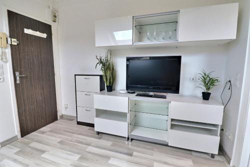 - un salon avec une télévision et des placards blancs dans l'établissement Le P'tit Nid - Cosy et Lumineux - Mon Groom, à Troyes