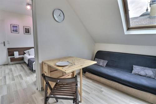 Cette petite chambre comprend un bureau, un canapé et une table. dans l'établissement Le P'tit Nid - Cosy et Lumineux - Mon Groom, à Troyes