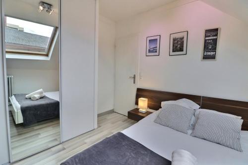 une chambre avec deux lits et un grand miroir dans l'établissement Le P'tit Nid - Cosy et Lumineux - Mon Groom, à Troyes