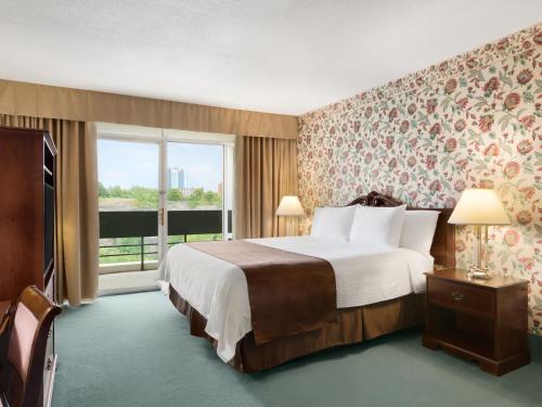 una camera d'albergo con un letto e una grande finestra di Travelodge by Wyndham Niagara Falls Fallsview a Niagara Falls