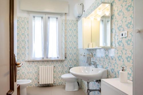 une salle de bain avec un lavabo, des toilettes et un miroir dans l'établissement S303 - Sirolo, ampio trilocale in zona tranquilla, à Sirolo
