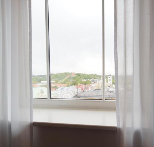 an open window with a view of a city at Novotel Vilnius Centre in Vilnius