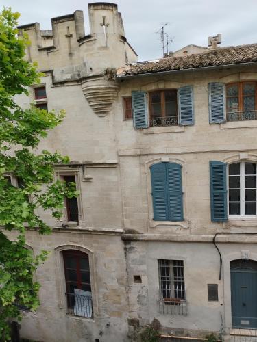- un bâtiment ancien avec des portes et des fenêtres bleues dans l'établissement Le 63 des teinturiers, à Avignon