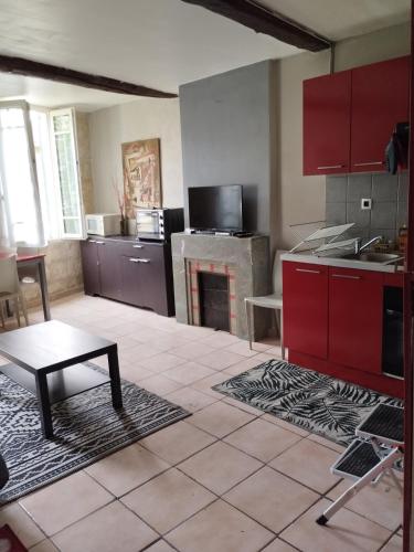 une grande cuisine avec des armoires rouges et une cheminée dans l'établissement Le 63 des teinturiers, à Avignon