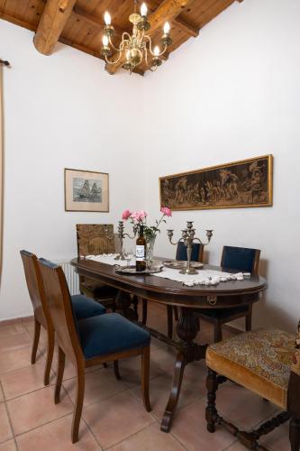 a dining room with a table with chairs and a chandelier at The Olive Mill House - Luxe Villa, Classic Charm in Prinés