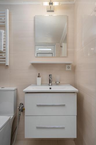 a bathroom with a white sink and a mirror at The Olive Mill House - Luxe Villa, Classic Charm in Prinés